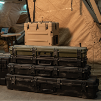 Valises militaires SKB empilées dans un environnement opérationnel sous tente