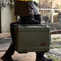 Valise de protection SKB portée par une personne dans un environnement de travail industriel