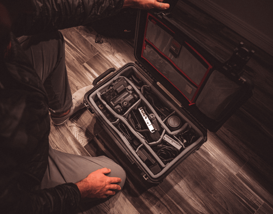 Valise rigide SKB ouverte avec séparateurs réglables, remplie d'appareils photo et de matériel vidéo, vue de dessus dans un environnement intérieur.